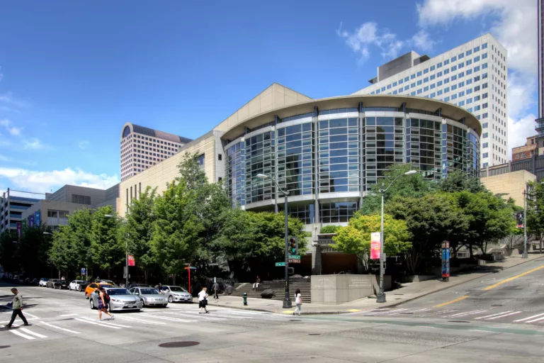 Exterior daylight view of Benaroya Hall and its glass-enclosed lobby, looking northeast from the corner of Second Avenue and University Street