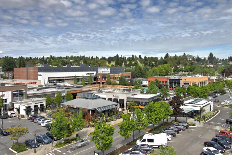 Aerial daylight view of University Village’s retail buildings, parking lot, sidewalks, and landscaping