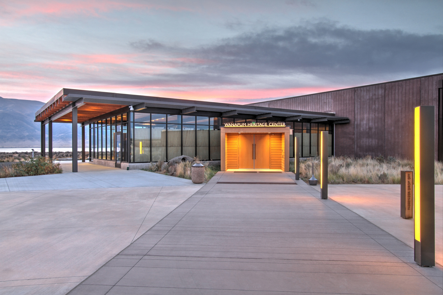 Exterior view of the Wanapum Heritage Center's illuminated entry walkway at twilight