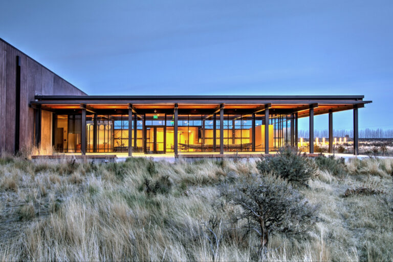 An eastern exterior view of the Wanapum Heritage Center's illuminated lobby at twilight