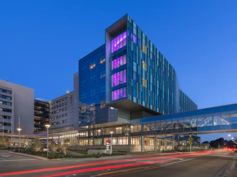 Exterior twilight view of Advocate Christ Medical Center’s eight-story Patient Care Tower with pedestrian skybridge