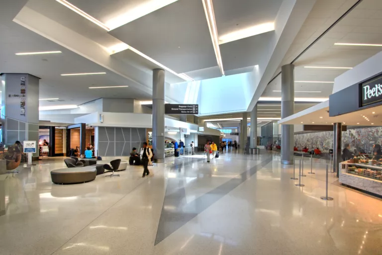 Interior view of San Francisco International Airport's Terminal 3 East Retrofit and Expansion with a coffee shop and travelers moving through the concourse