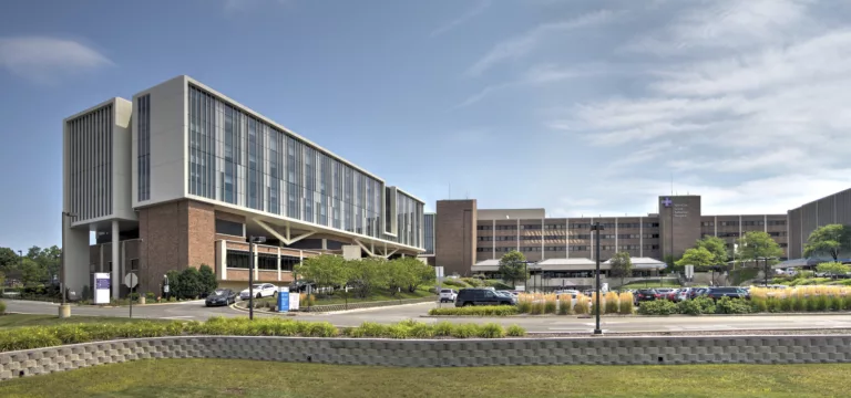 Exterior daylight view of the five-story Advocate Good Samaritan Hospital Expansion with a central parking lot and surrounding landscape features