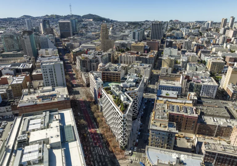 Exterior aerial view of the 12-story Serif Residences and The Line Hotel featuring a landscaped rooftop with outdoor seating and surrounding downtown buildings