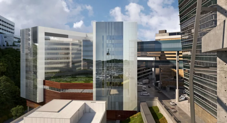 Exterior daylight rendering of the 14-story Oregon Health & Science University Hospital Expansion with pedestrian skybridges and a central plaza with landscaping