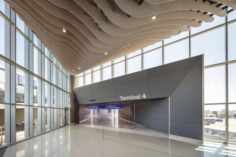 Interior daylight view of Phoenix Sky Harbor International Airport's Terminal 4 expansion featuring floor-to-ceiling windows and ornamental ceiling