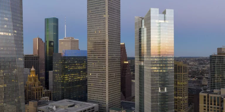 Aerial twilight view of the 46-story Texas Tower surrounded by downtown high-rise buildings