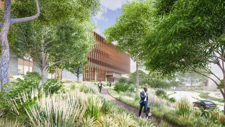 Exterior daylight rendering of the staff garden at the U.S. Embassy in Lilongwe featuring lush landscaping and trees, a footpath with three visitors, and a vehicle traveling on the adjacent roadway