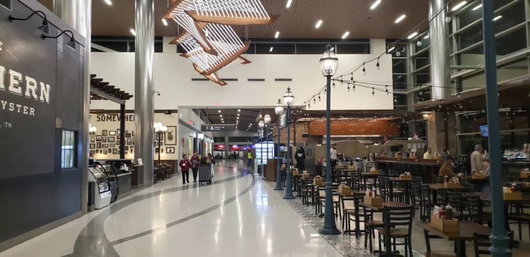 Interior daylight image of Nashville International Airport's Concourse D expansion with views of restaurants and an ornamental ceiling display