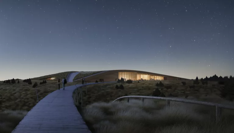 Rendering of the Theodore Roosevelt Presidential Library at star-filled twilight with a pedestrian bridge leading to the illuminated lobby and surrounded by grasslands and scrub
