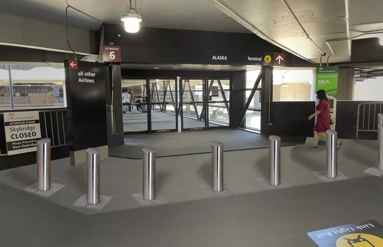 Daylight image of steel bollards in front of the pedestrian skybridge leading to Sea-Tac International Airport's main terminal