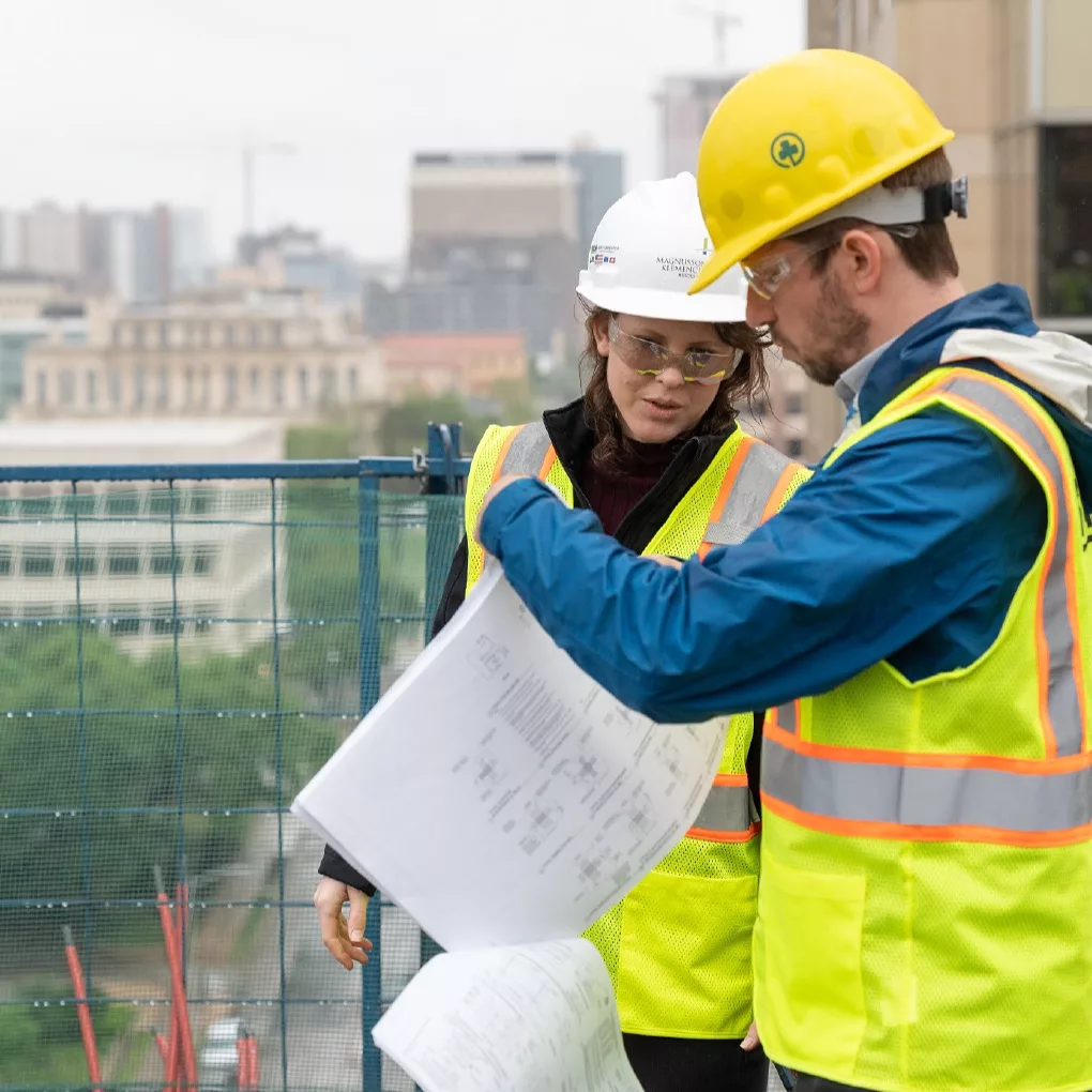 Two MKA engineers on a construction site looking at building plans